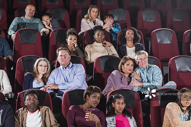 多民族观众在电影院看恐怖电影图片素材