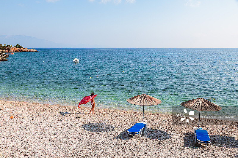沙滩上穿着纱笼的女人。Zakynthos，希腊群岛图片素材