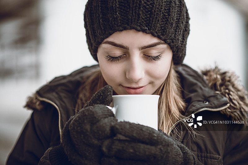 可爱的金发女孩在冬天喝热可可图片素材