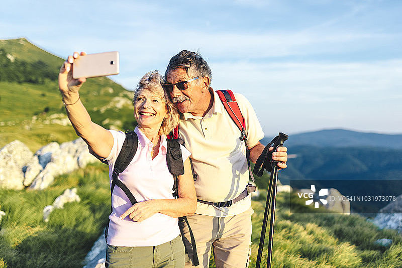 一对老年夫妇在山里远足时自拍图片素材