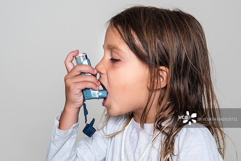 一个小女孩在吃她的哮喘药图片素材