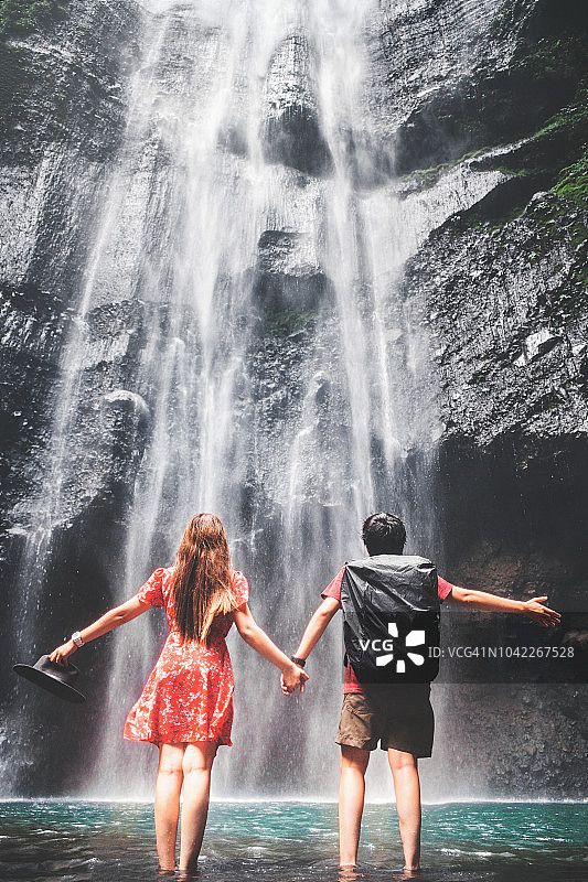 一对夫妇站在印尼东爪哇马达卡里普拉瀑布附近图片素材