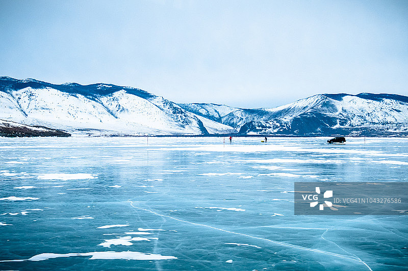 俄罗斯西伯利亚冰湖上的两个人和一辆车图片素材