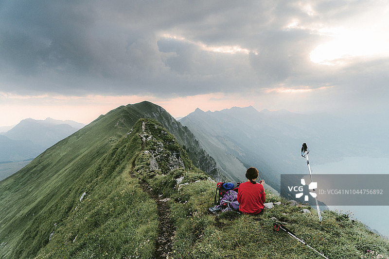 坐在瑞士阿尔卑斯山山脊上的女人图片素材