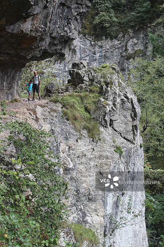 父亲和儿子在拉斯萨纳斯峡谷路线。西班牙阿斯图里亚斯。图片素材