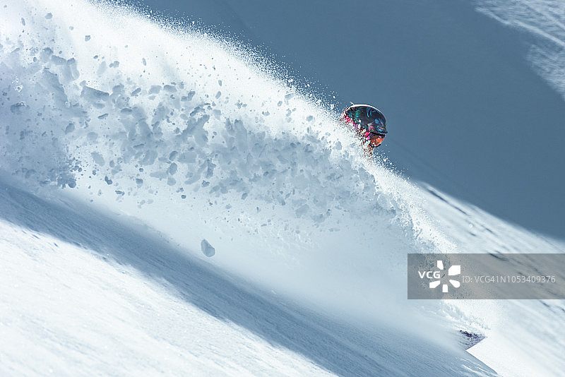 滑雪者在新鲜的粉状雪中制造巨大的雪飞溅图片素材