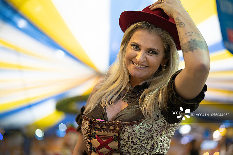在巴西圣卡塔琳娜的布鲁梅瑙啤酒节上，德国血统的妇女赠送帽子图片素材