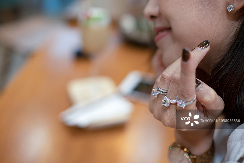 女人的手拿着优雅的订婚钻石戒指的特写图片素材