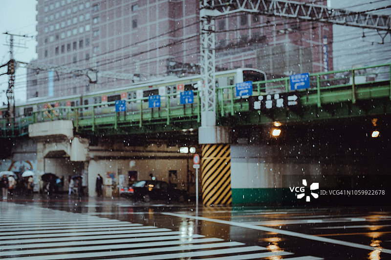 在东京的降雪期间，繁忙的通勤者在市中心街道上上下班和交通图片素材