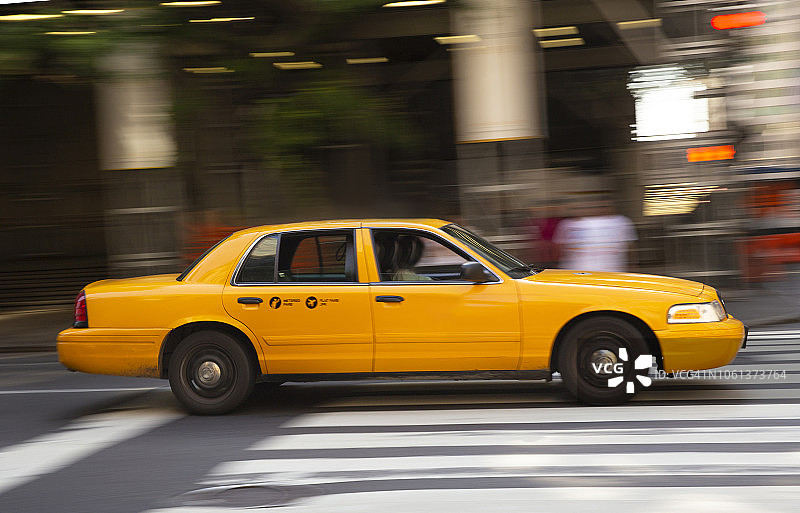 一辆黄色出租车在美国纽约曼哈顿超速行驶图片素材