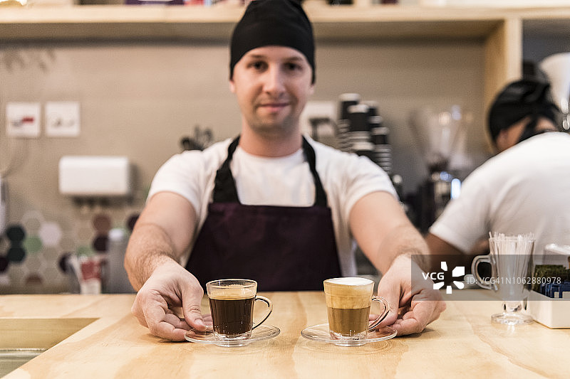 咖啡师在咖啡柜台上提供两杯浓缩咖啡图片素材