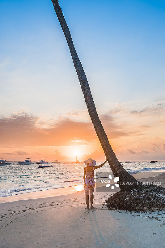 在热带海滩上欣赏日出的女人图片素材