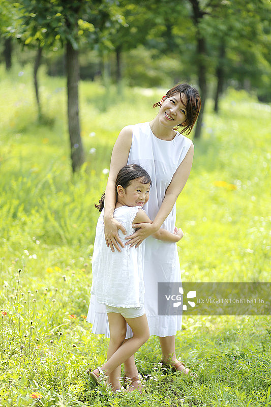 快乐的女儿和母亲在公园拥抱图片素材