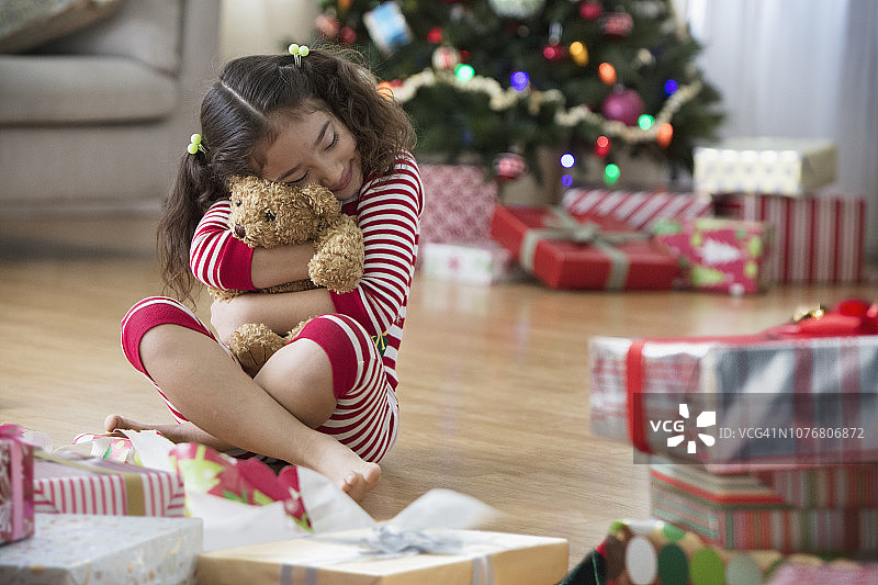 小女孩在客厅打开圣诞礼物图片素材
