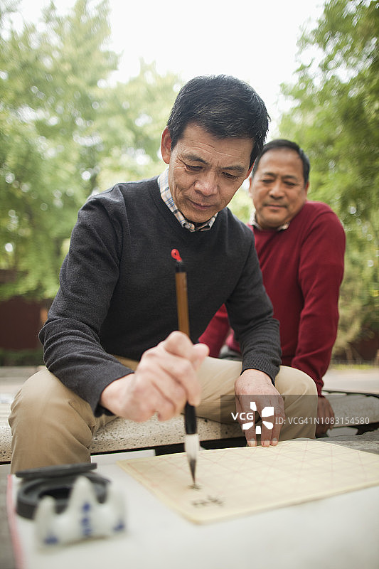 中国男人在公园里练习书法图片素材