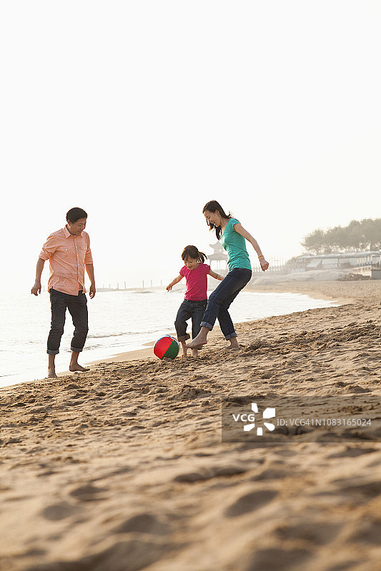 中国家庭在沙滩上玩球图片素材