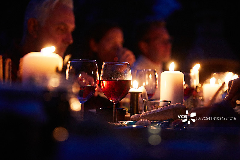 近距离的葡萄酒杯和面包燃烧蜡烛在餐桌上的晚餐派对图片素材