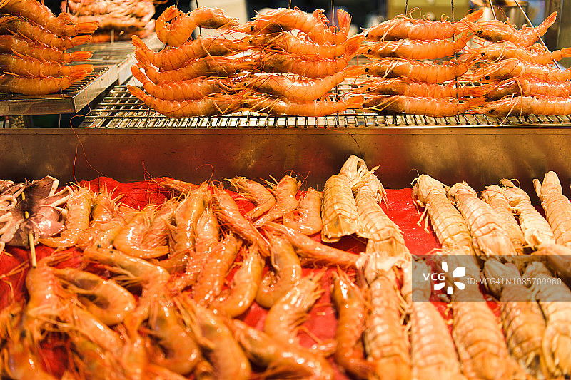 台湾高雄市晚上热闹街道上出售的烤虾图片素材