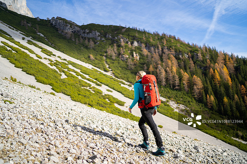 专注于在秋天爬山的女性登山运动员图片素材