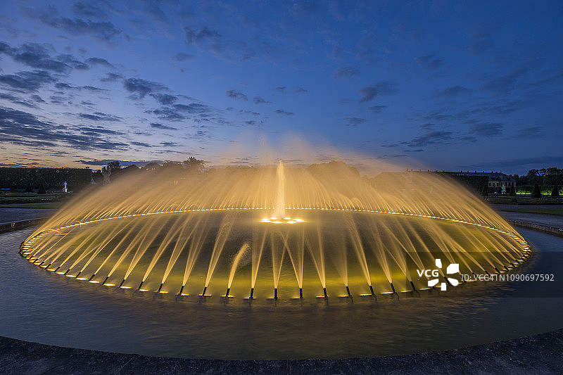 德国，下萨克森州，汉诺威，Herrenhaeuser Gaerten，傍晚的花坛喷泉图片素材