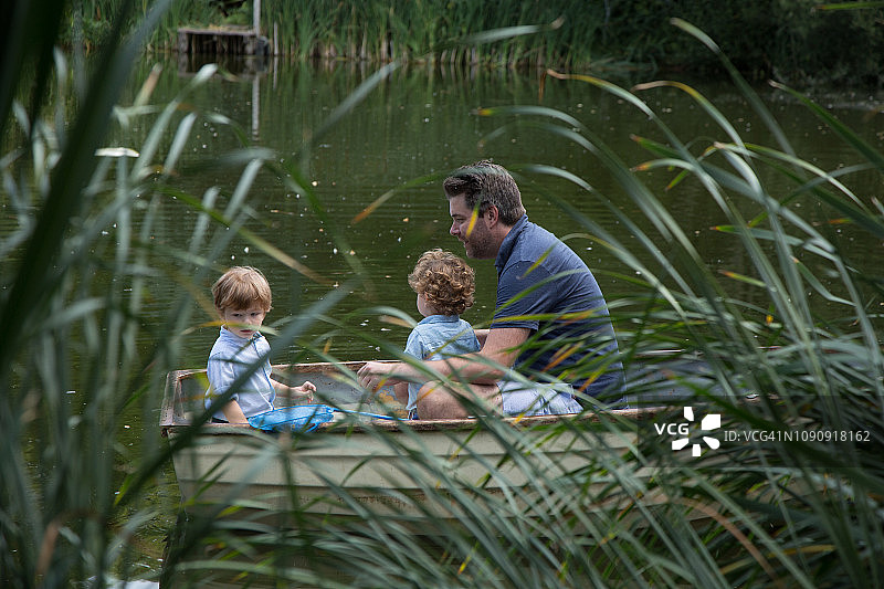 父亲和孩子们在湖中划船图片素材