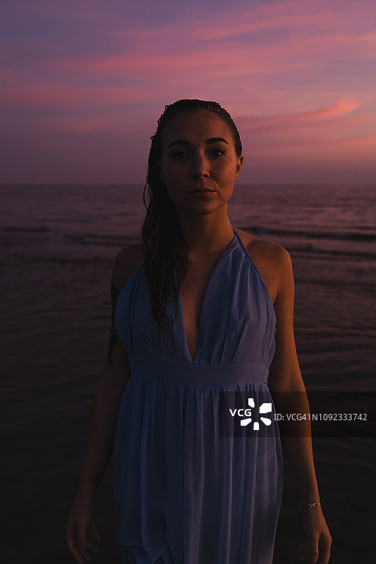 日落时分，年轻女子在大海前的肖像图片素材