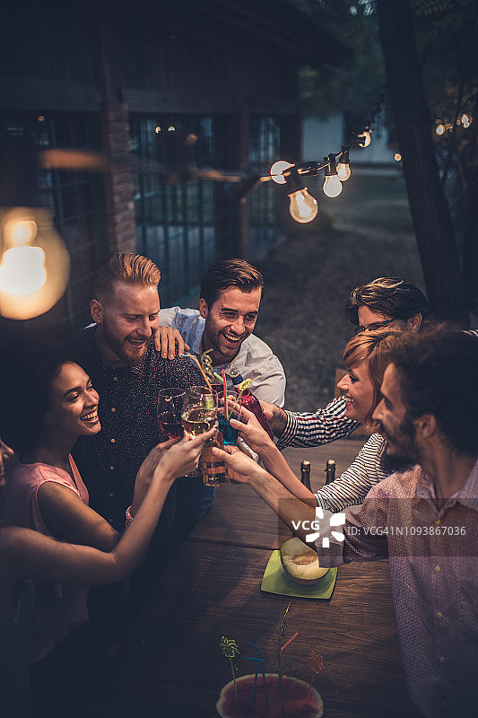 一群欢快的人在一个晚上的聚会上喝酒，玩得很开心。图片素材