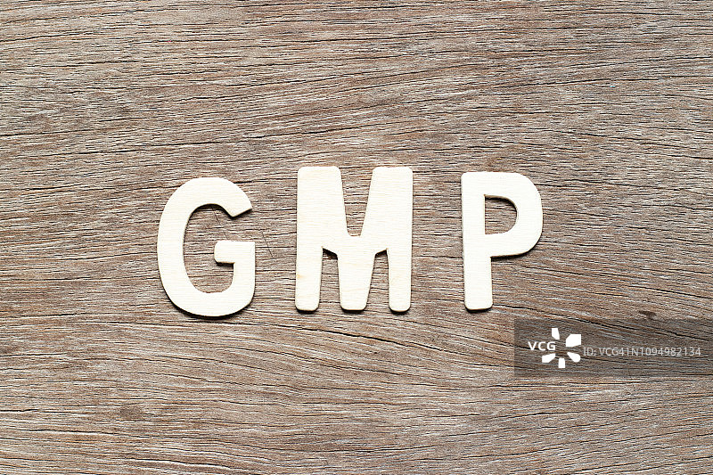 在木材背景上的字母字母GMP(良好生产规范的缩写)图片素材