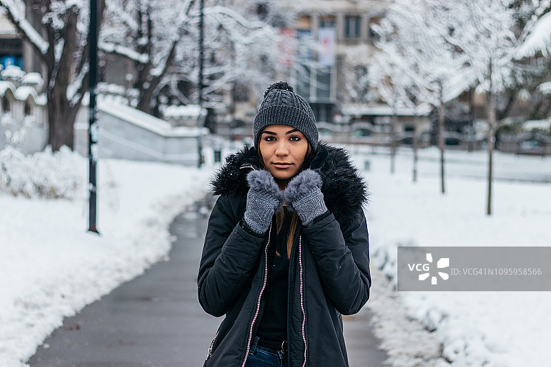 在白雪覆盖的公园里散步的女人图片素材