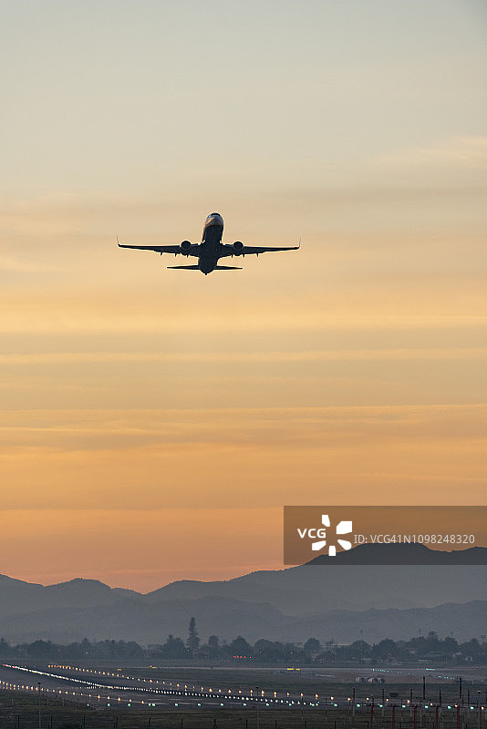飞机在日落起飞，阿利坎特-埃尔切机场，科斯塔布兰卡，欧洲，西班牙图片素材