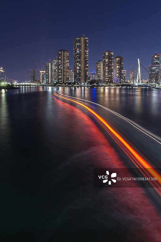 东京天际线美丽的滨水夜景，船屋灯光的踪迹，在隅田河，日本，东京。图片素材