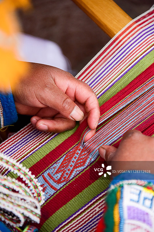 一位秘鲁妇女在背带织布机上织布图片素材