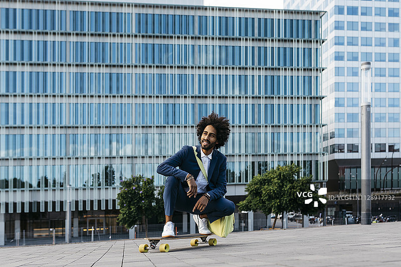 西班牙，巴塞罗那，年轻的商人蹲在滑板城里图片素材