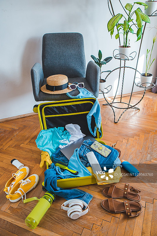 旅行的概念。黄色手提箱，周围有不同的东西图片素材