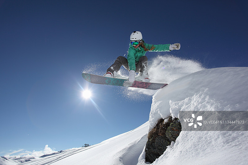 年轻女子跳滑雪板，Mayrhofen，蒂罗尔，奥地利图片素材