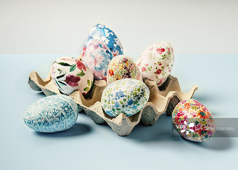 复活节彩蛋装在蓝色背景的蛋盒里图片素材
