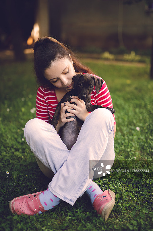 年轻的雌性抱着一只小狗图片素材