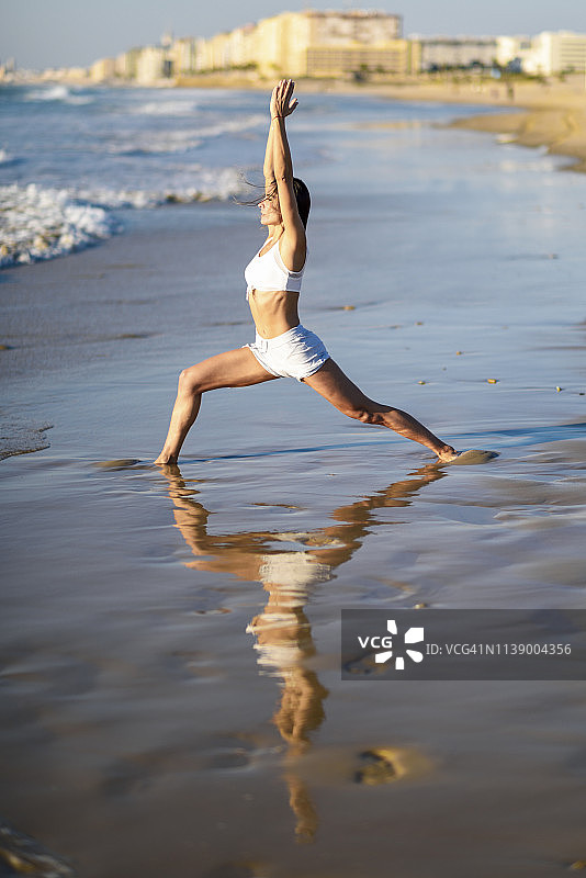 在海滩上做瑜伽的运动女人图片素材