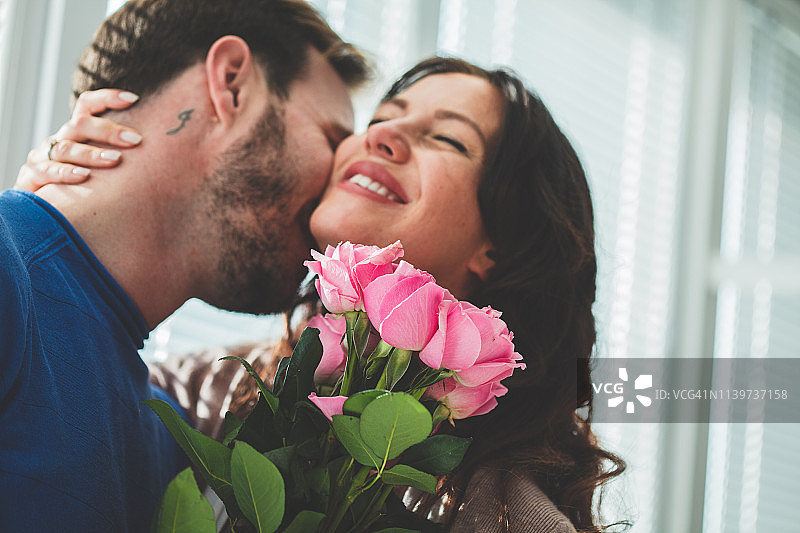 男人在送花给妻子后亲吻她图片素材