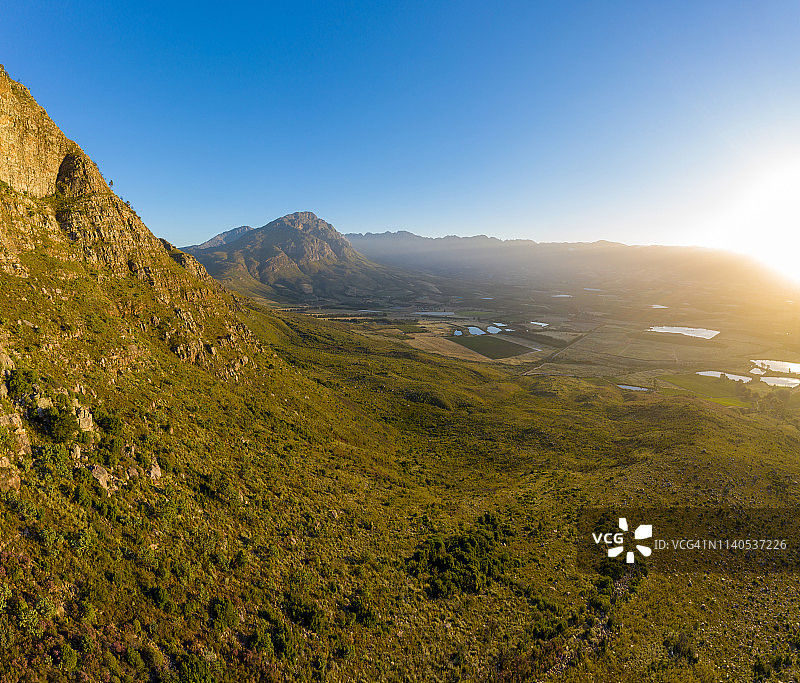 4K南非西开普省葡萄酒庄园的葡萄园美景，风景如画的山脉和蓝天图片素材