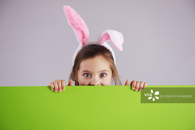 穿着兔子服装的女孩举着绿色的旗帜。Debica、波兰图片素材