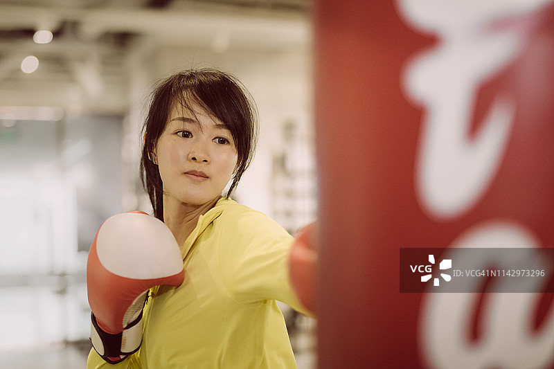 年轻的亚洲女子拳击与红色手套图片素材