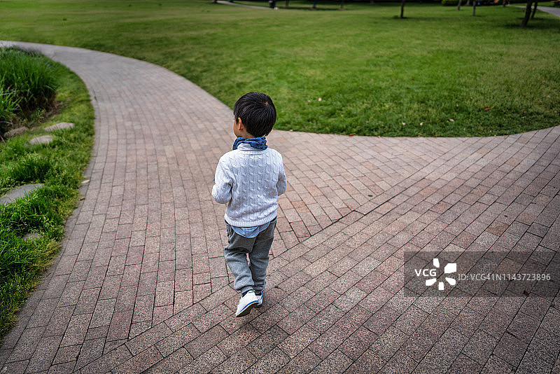 一个小男孩在公园里散步的肖像，人民广场，黄浦区，中国上海图片素材