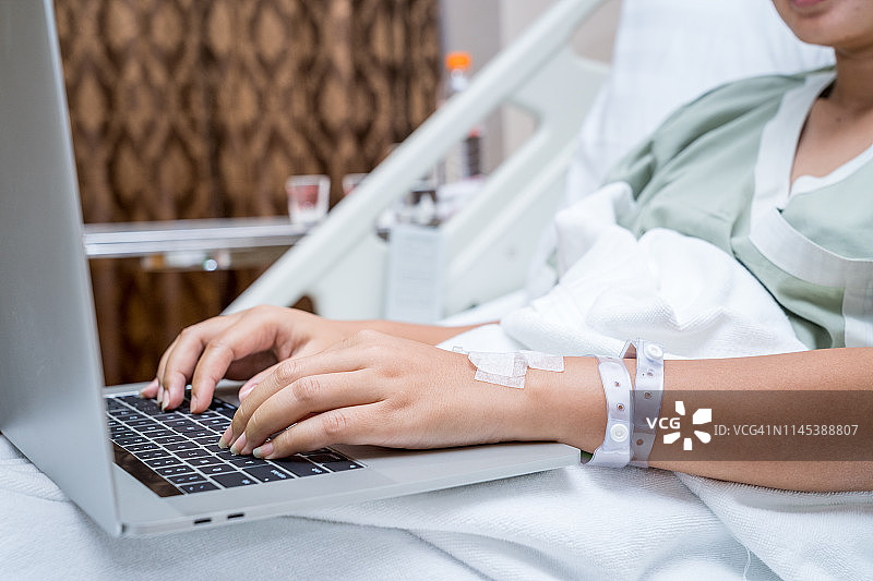病人的双手与电脑在病房工作图片素材
