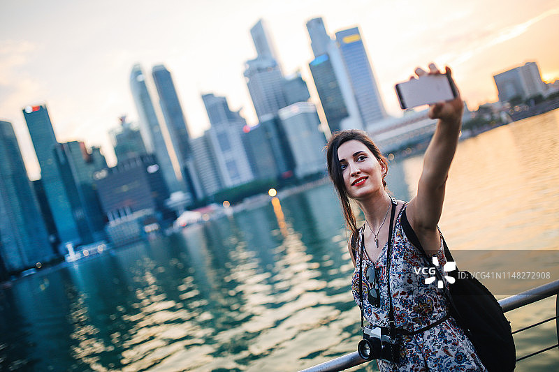 年轻游客在新加坡自拍或视频通话图片素材