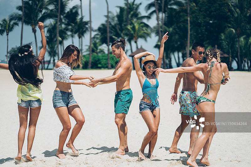 一群朋友在海滩上开心地跳舞图片素材