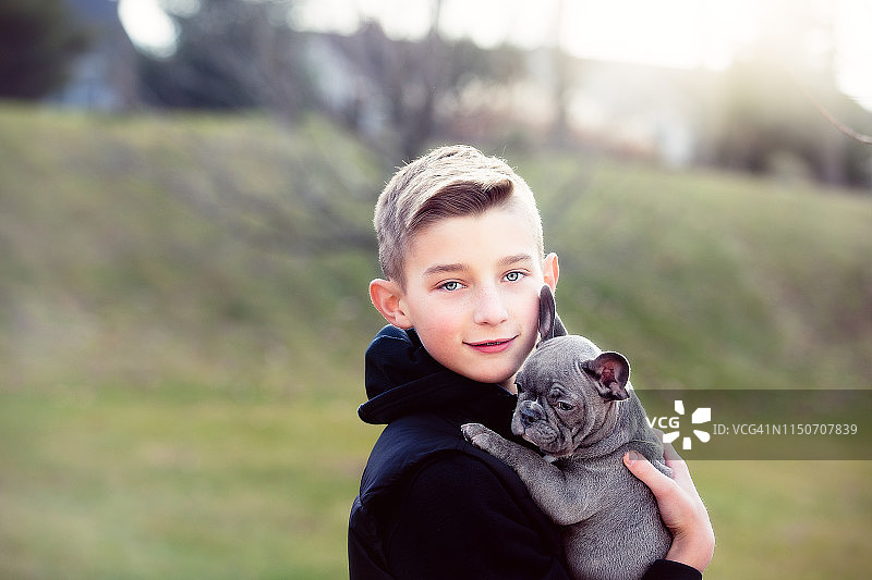 男孩抱着小狗外出图片素材