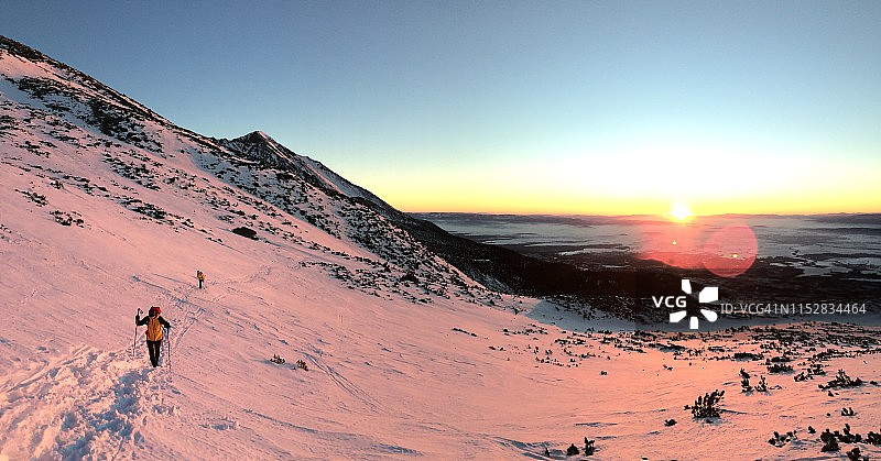 登山者的剪影。日落时壮丽的山景图片素材
