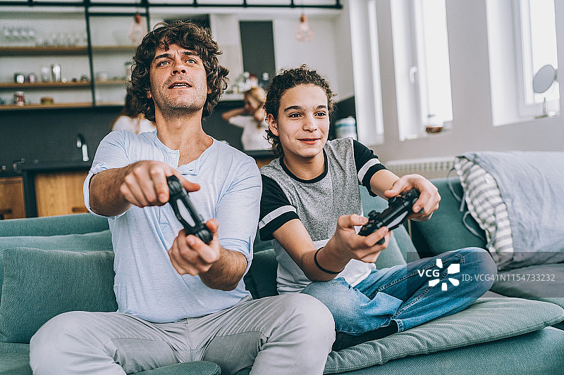 父亲和儿子在玩电子游戏图片素材