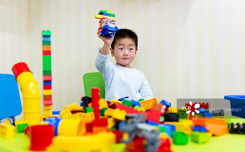 小男孩在玩五颜六色的玩具积木图片素材